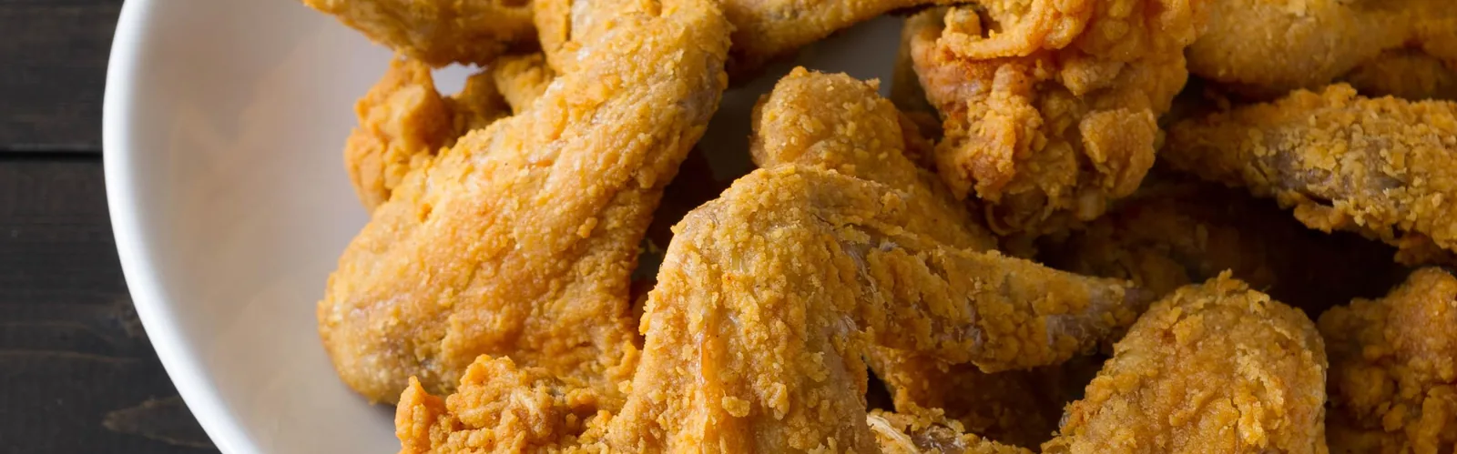 Crispy fried chicken wings and drumsticks piled in a bowl.