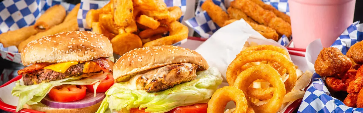Overhead spread of burgers, wings, sandwiches and fries