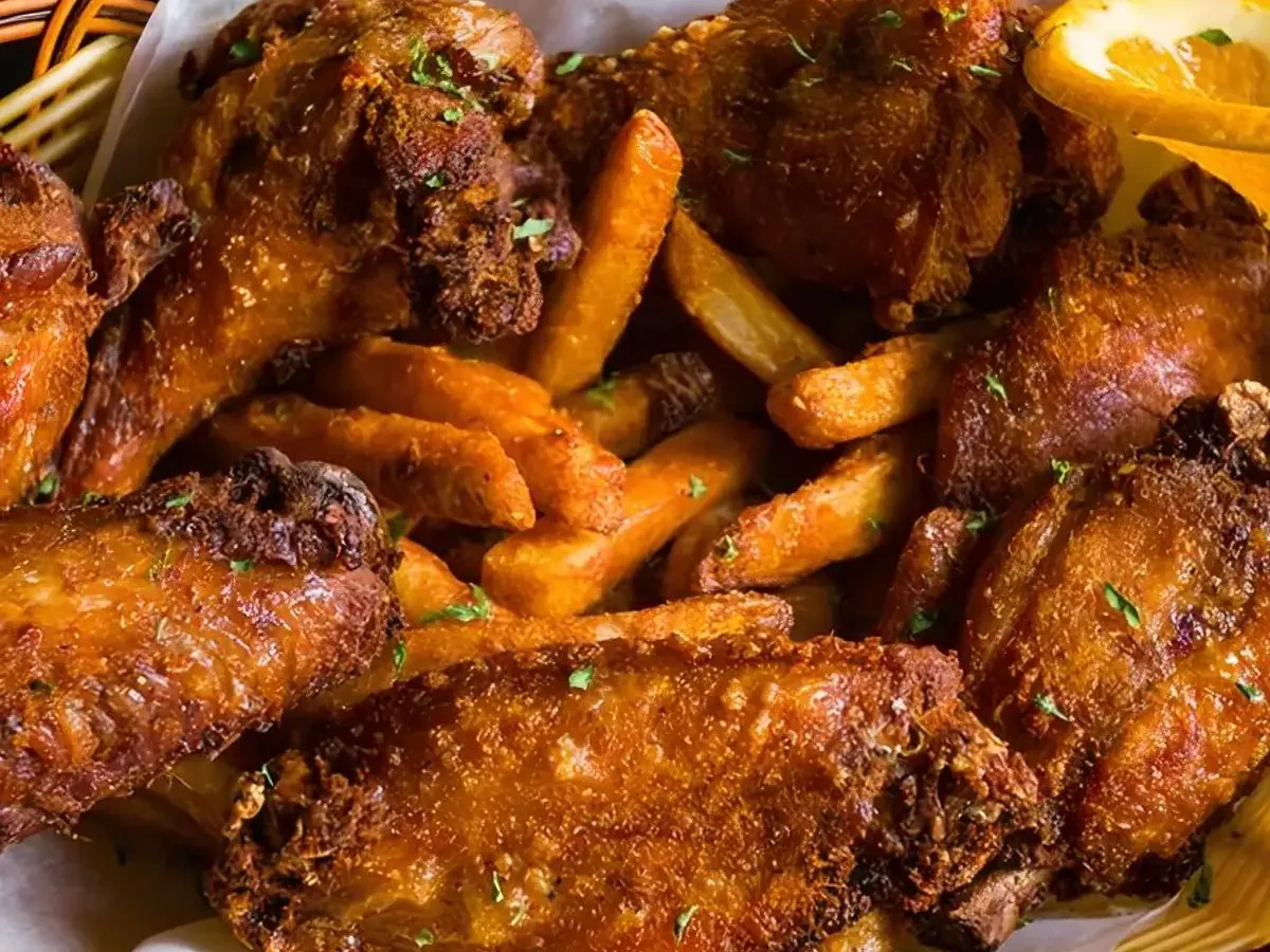 Fried chicken wings and fries in a basket