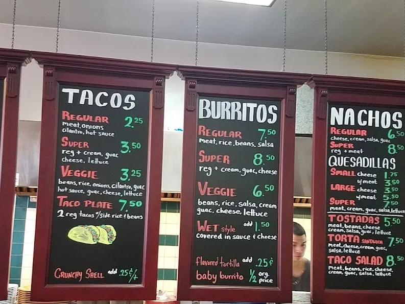Chalkboard menu boards listing tacos, burritos, and nachos with prices.