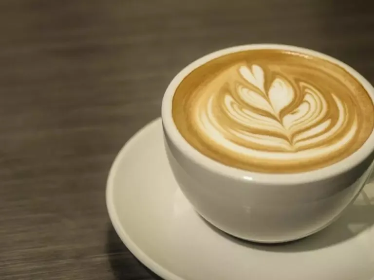A cup of cappuccino with heart-shaped latte art, viewed from above.