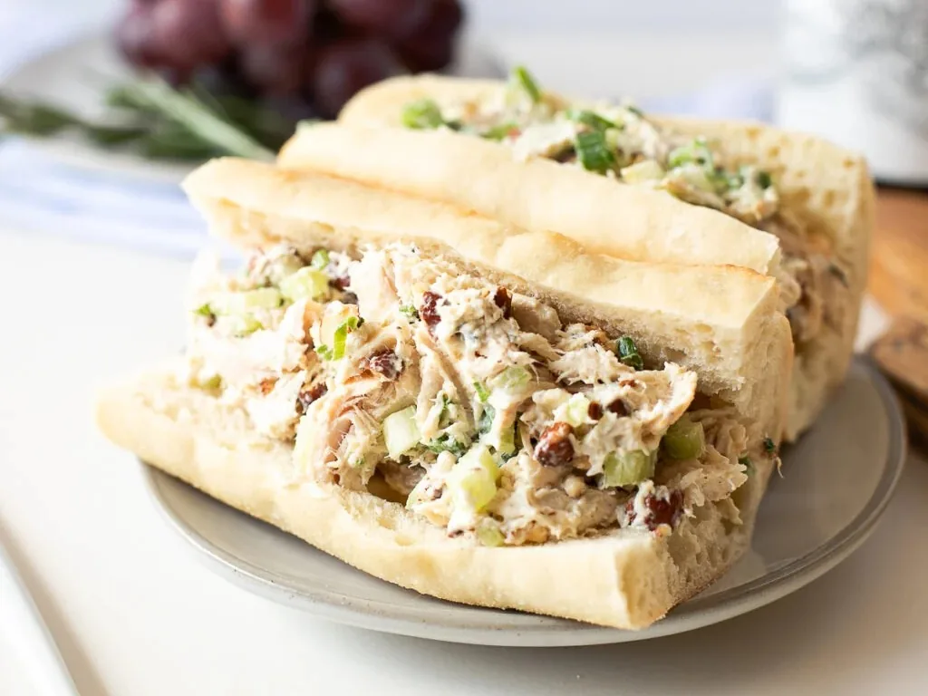 A sandwich filled with shredded chicken salad and celery on a plate.